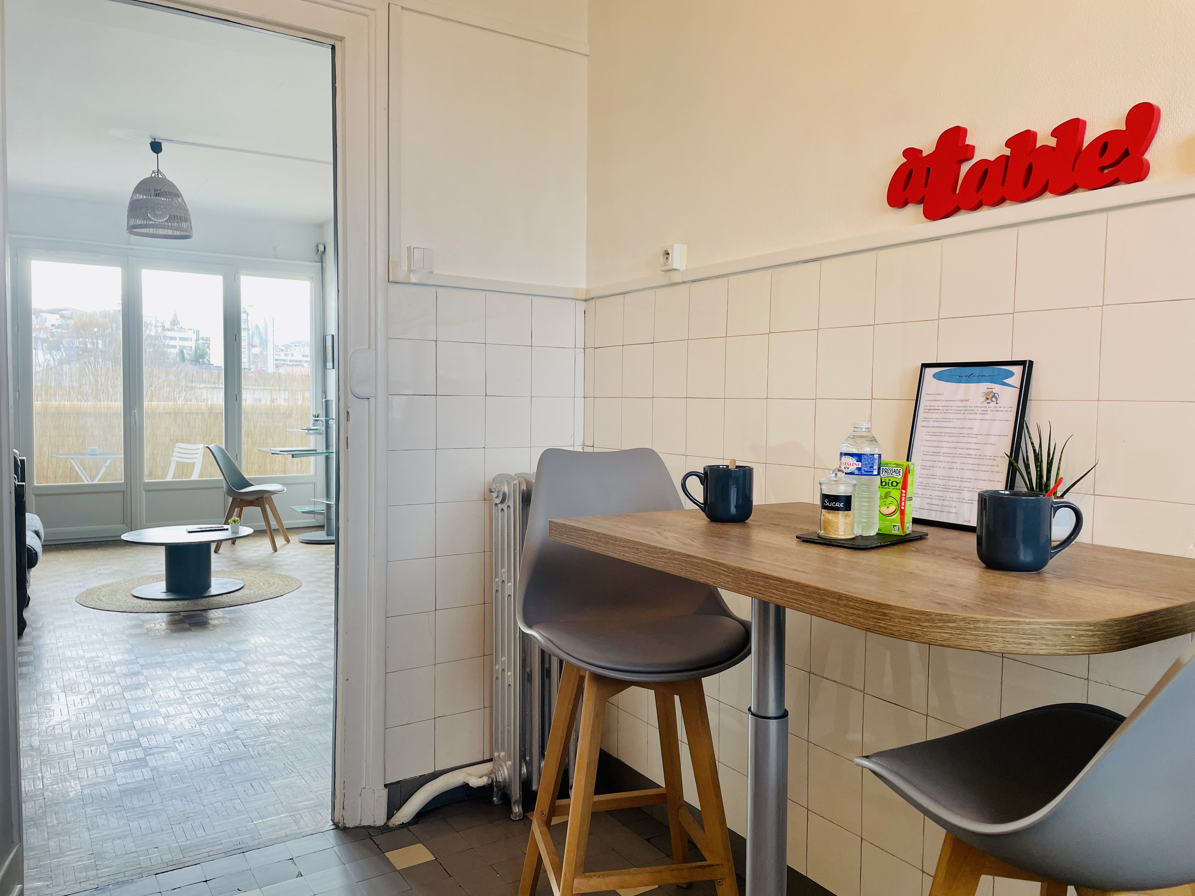 alt="Cuisine fonctionnelle de l’App’Art avec coin repas, table haute et tabourets modernes"