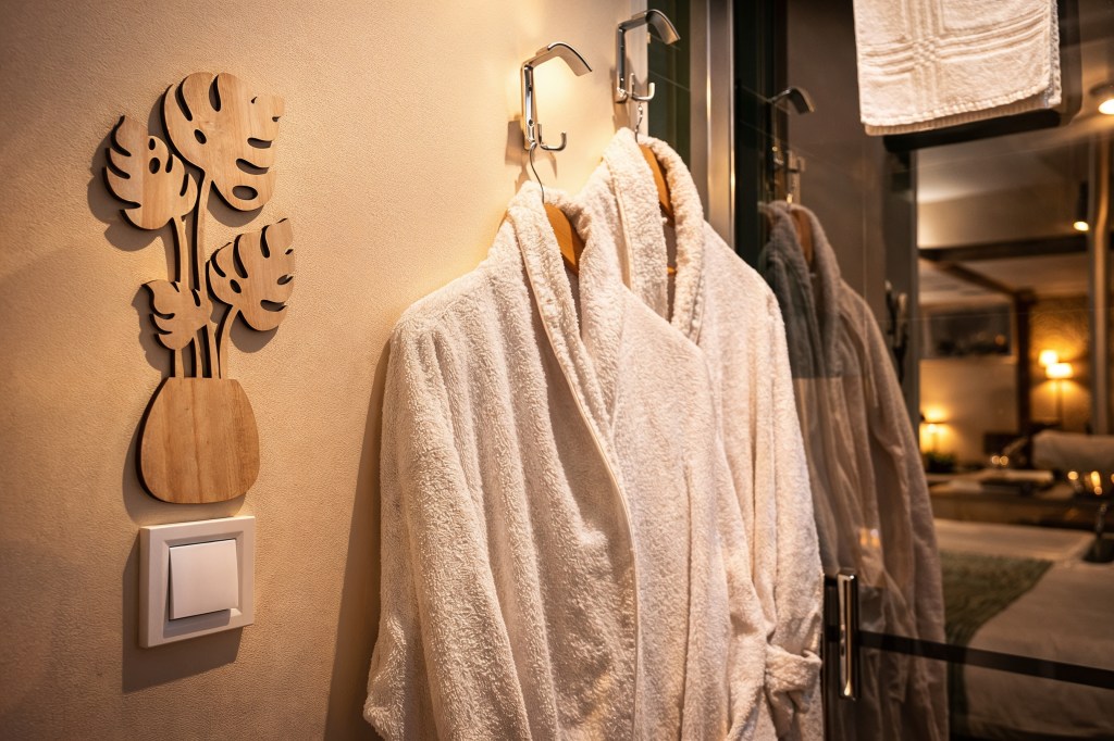 Peignoirs blancs moelleux suspendus près du jacuzzi dans un hébergement avec espace bien-être à Angoulême