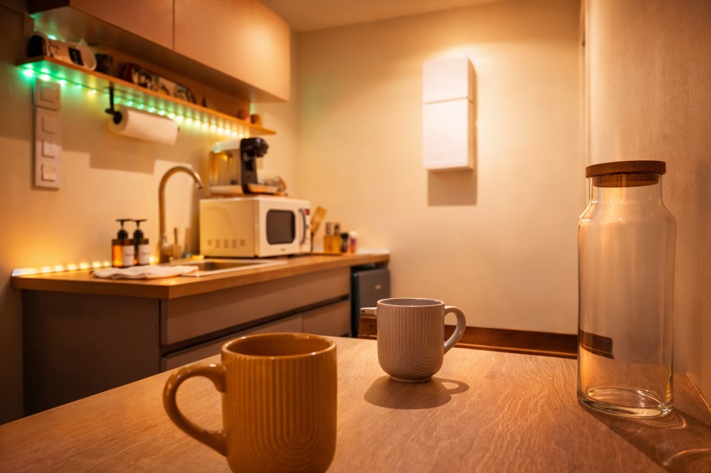 Cuisine équipée moderne avec coin repas, machine à café, micro-ondes et éclairage d'ambiance dans une location courte durée à Angoulême.